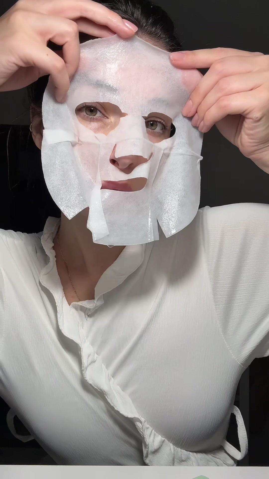 Woman Applying Sheet Mask to Face