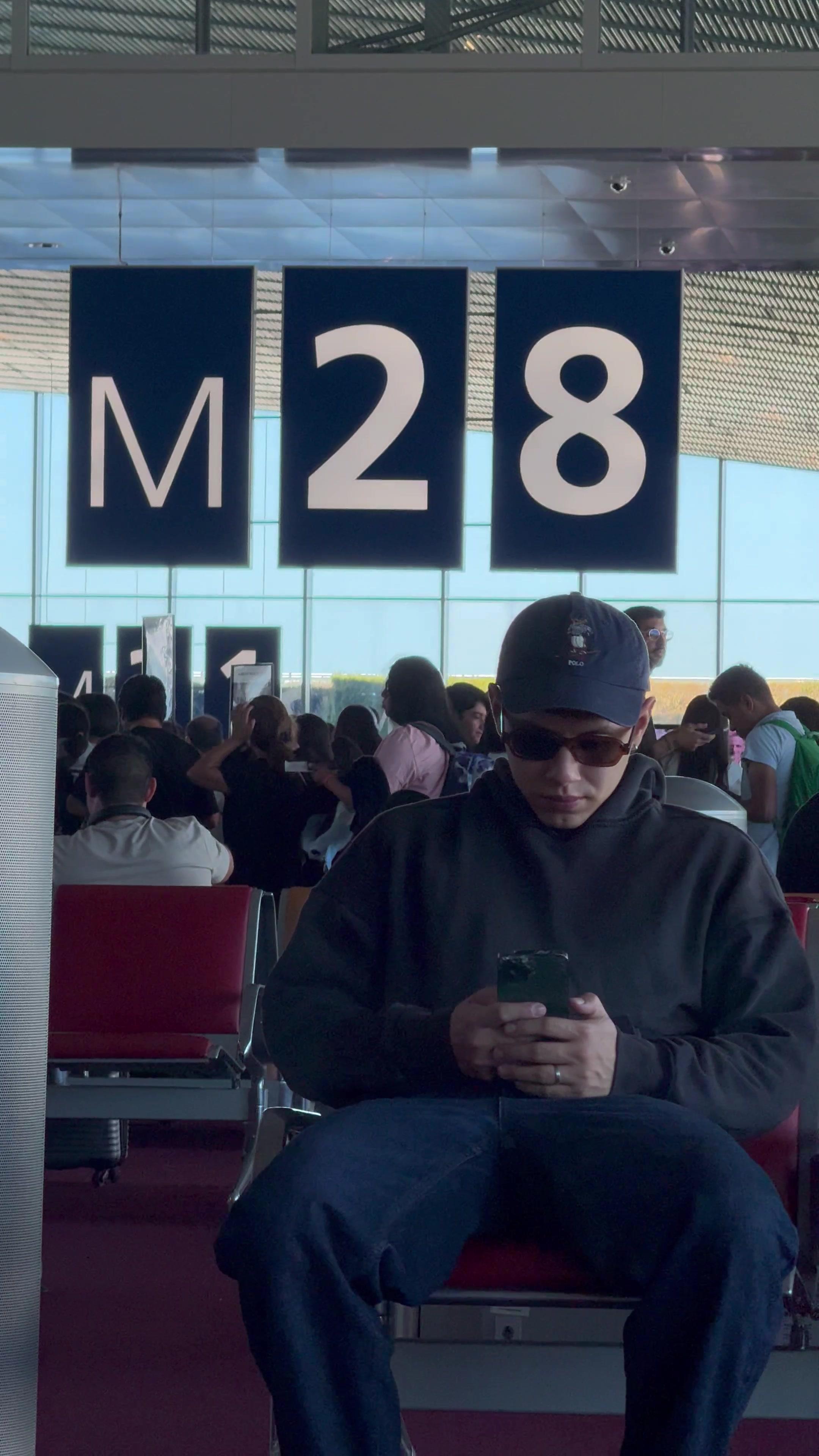 Man Checking Phone at Airport Gate