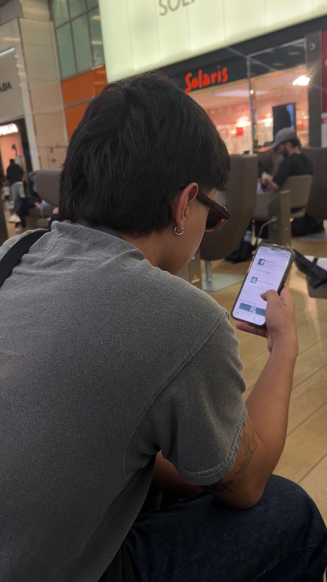 Man Browsing Phone in Waiting Area