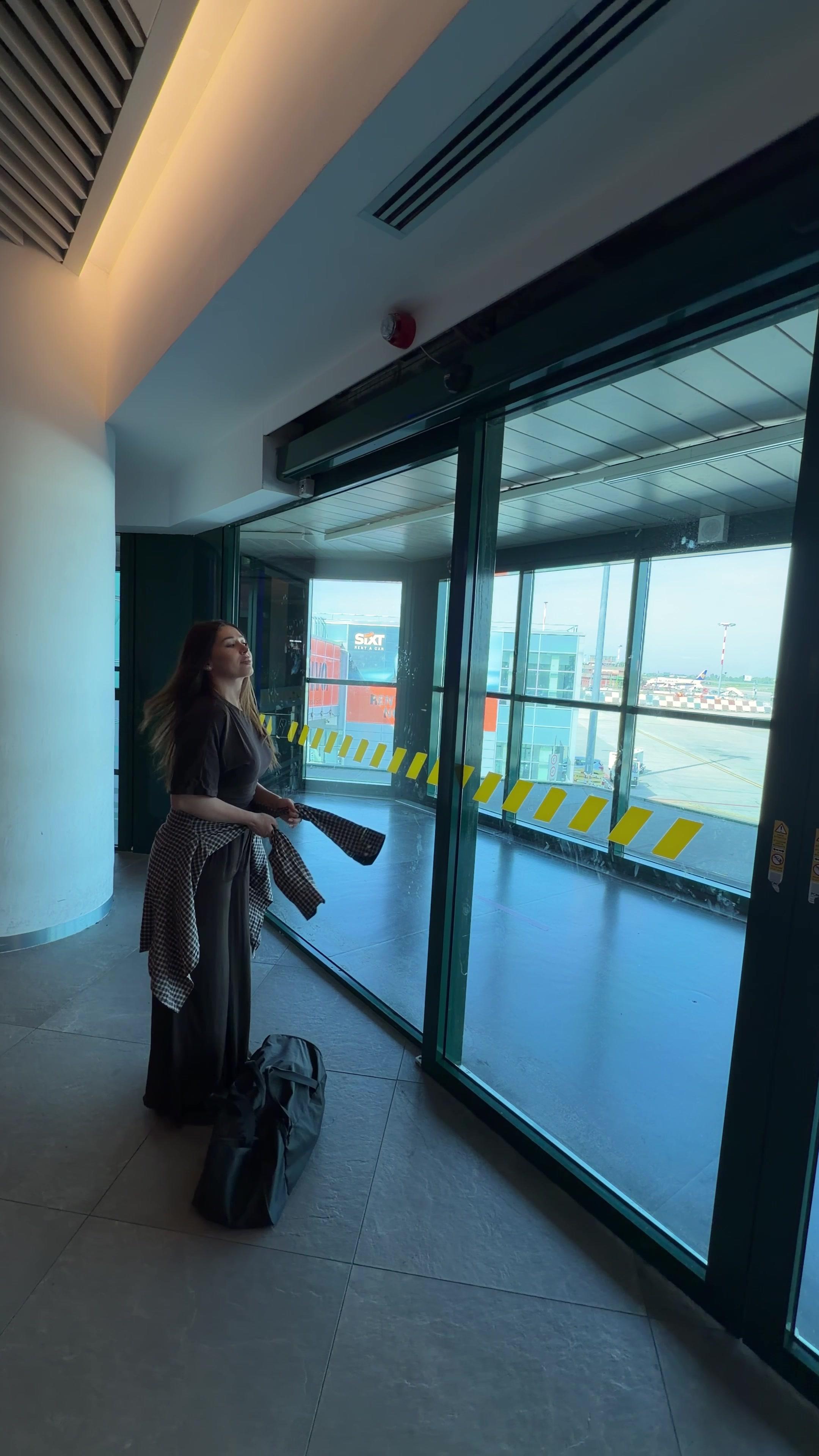 Woman Looking Out Airport Terminal Window