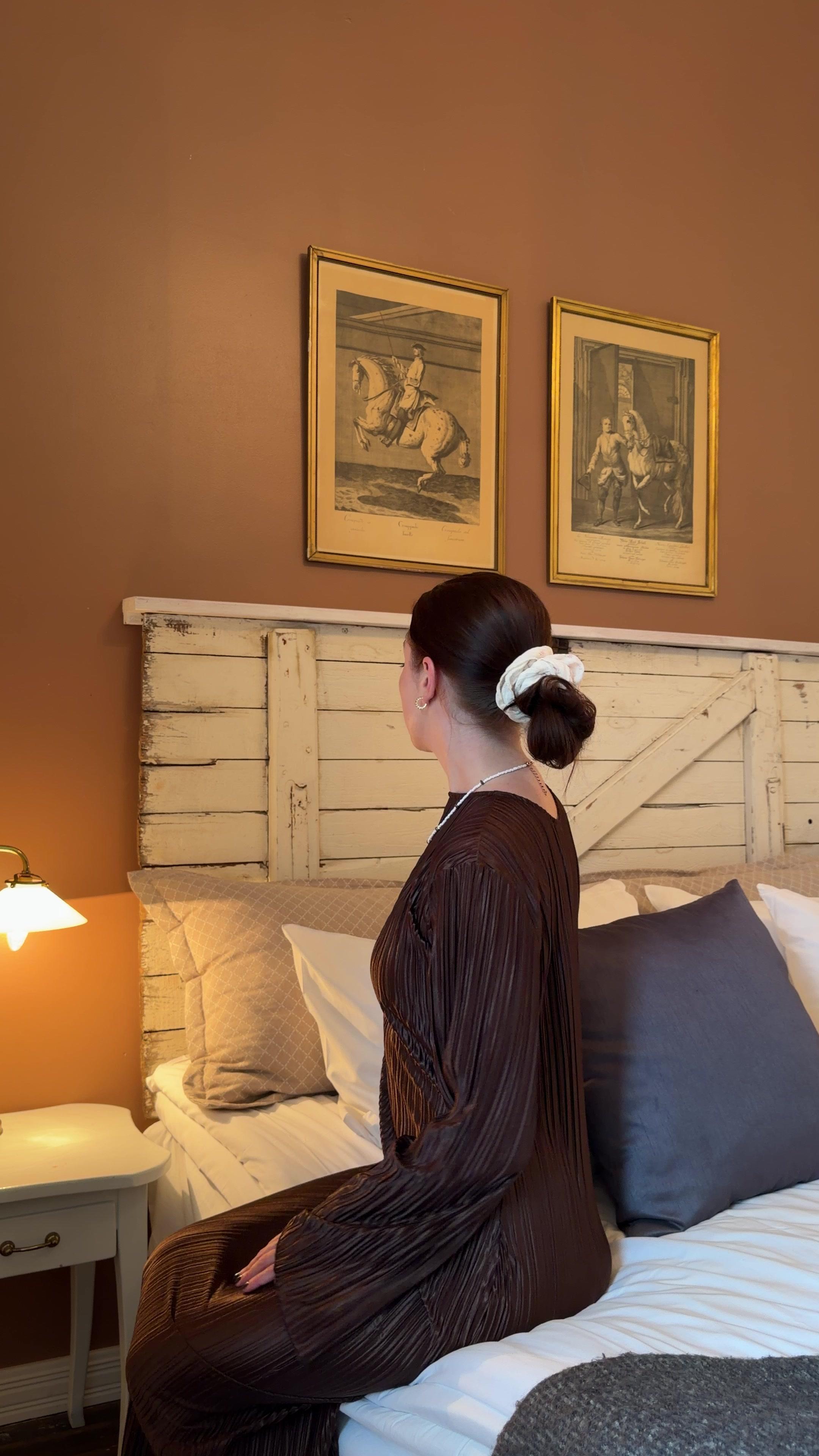 Woman Sitting on Bed in Bedroom
